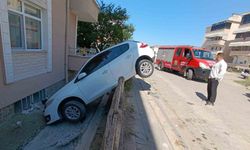 Otomobil bahçe duvarında asılı kaldı
