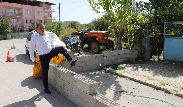 Briketlerle kapatılan yol, evine girişi engelliyor