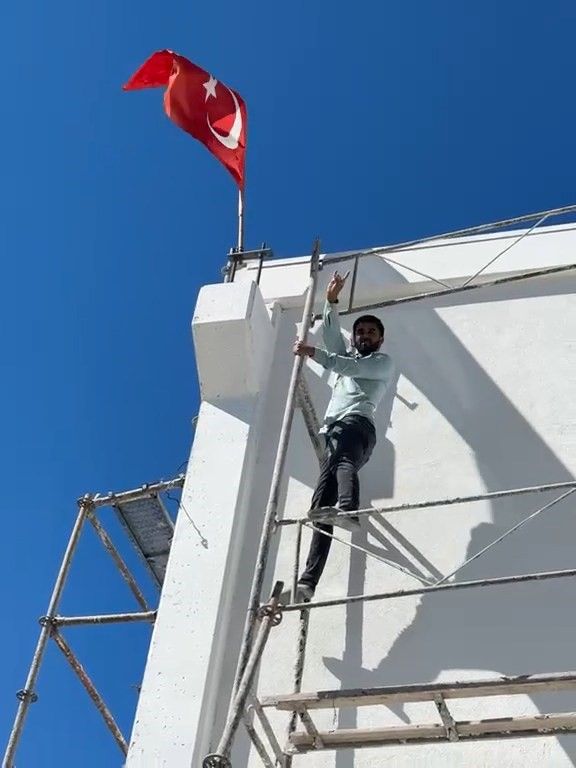 Rüzgar nedeniyle ters dönen Türk bayrağını düzeltmek için iskeleye tırmandı